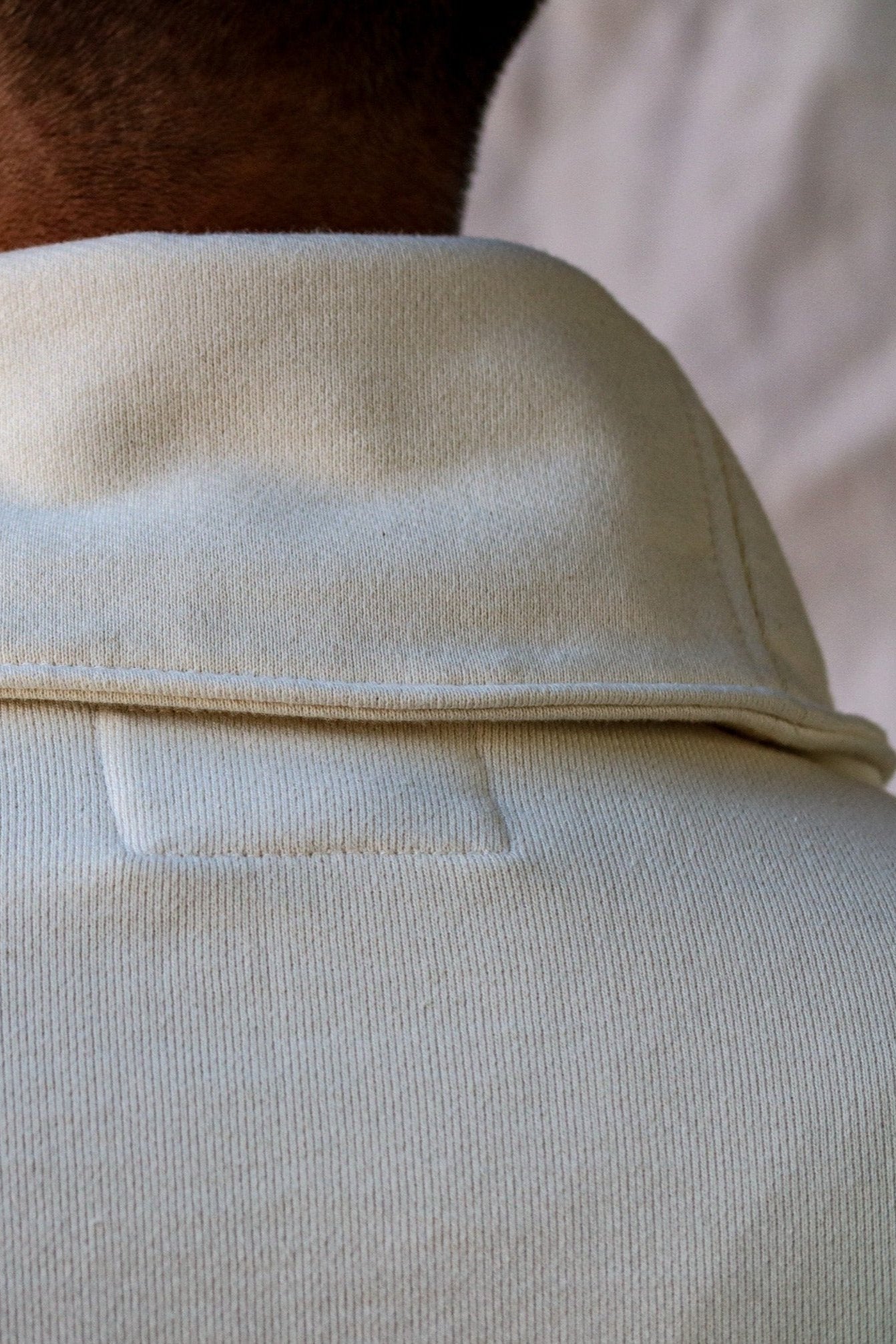 Close-up of natural French terry shawl collar and back seam on a men's pullover.
