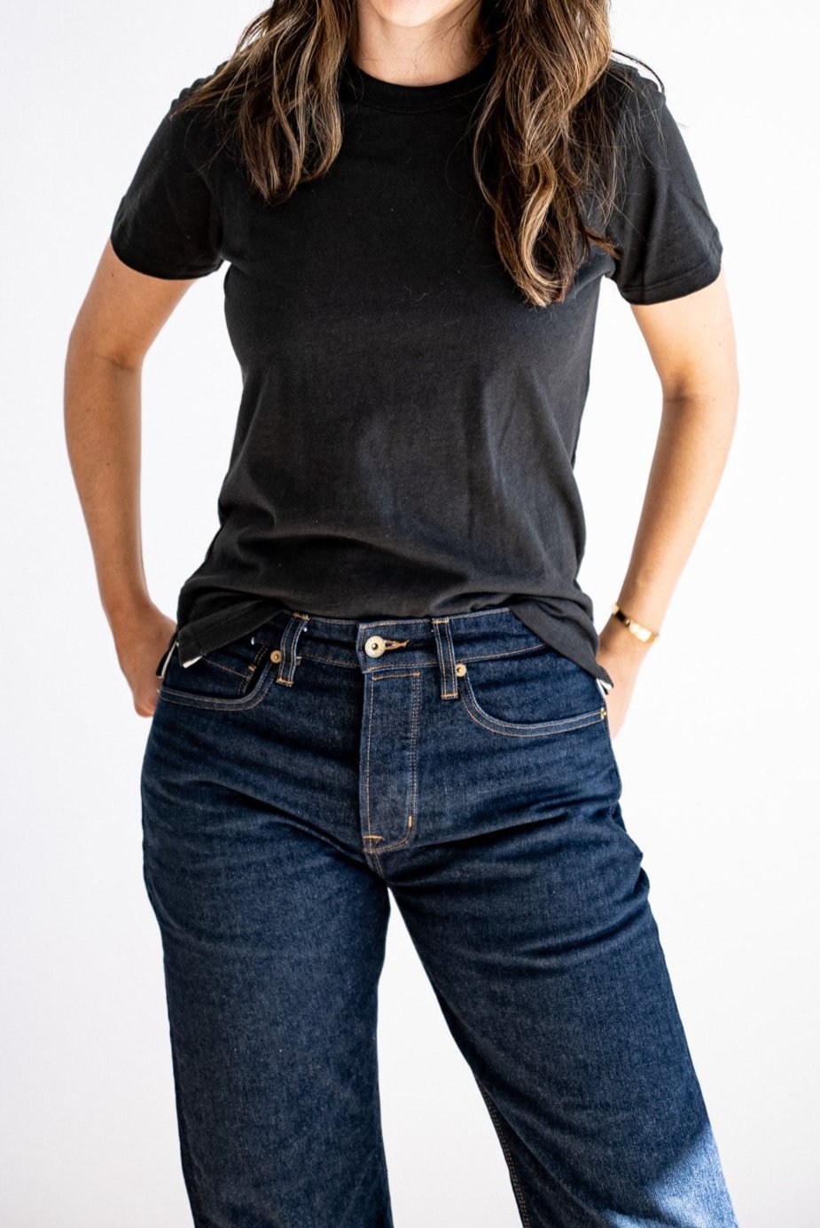 Women's Reyes boxy tee in basalt black, styled untucked with dark raw denim jeans.