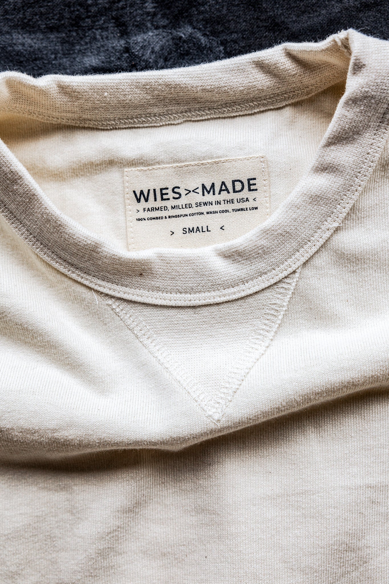 Close-up of natural cotton rugby jersey pullover collar with WiesMade USA-made label and V-stitch detail.