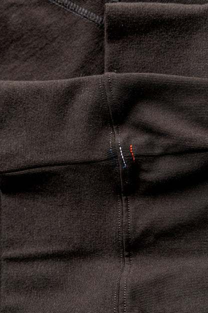 Close-up of basalt rugby jersey cotton with double-stitched seams and red and blue signature stitches.