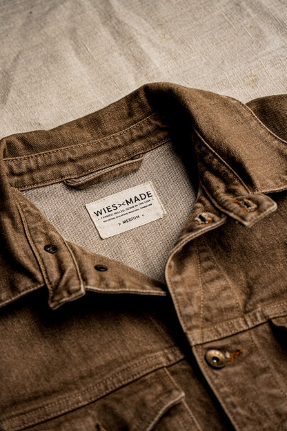 Close-up of the wheat broken twill denim jacket collar showing the WiesMade made-in-USA interior label and brass button.