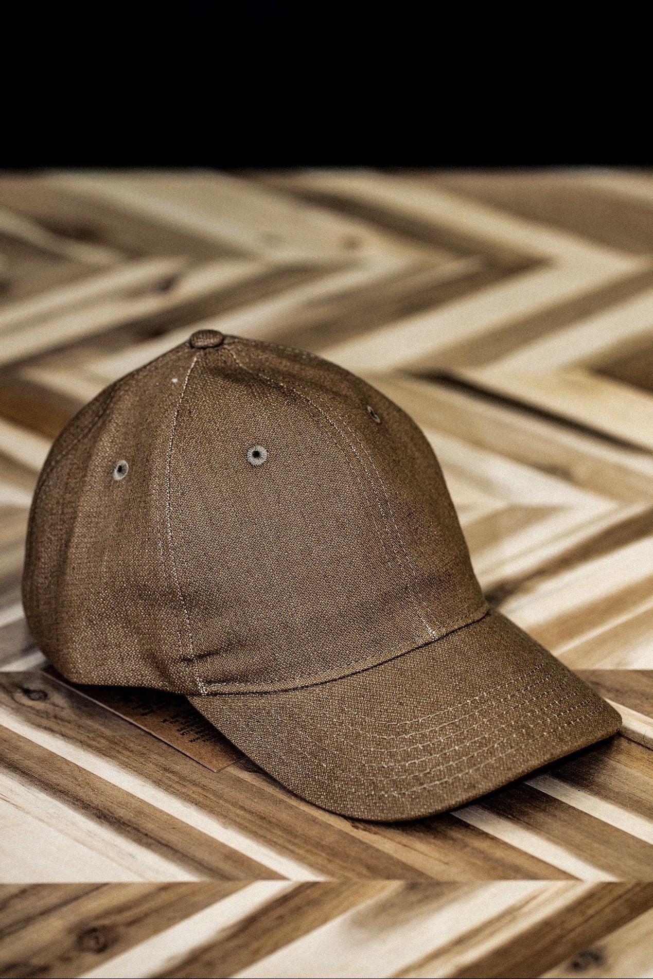 WiesMade wheat canvas ball cap front view on a herringbone wood surface.