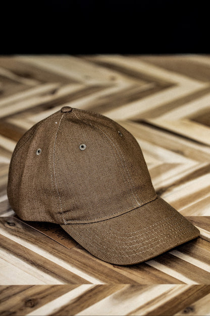 WiesMade wheat canvas ball cap front view on a herringbone wood surface.
