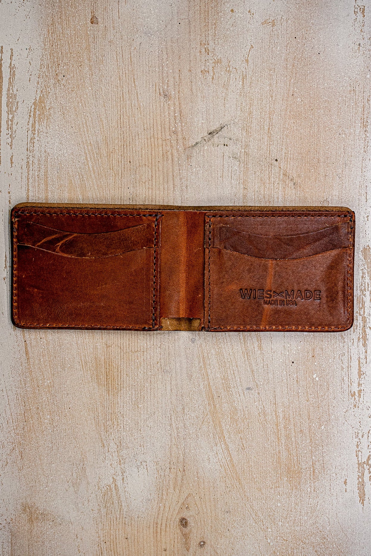 Open tan Horween leather bi-fold wallet showing card slots and WiesMade Made in USA stamp.