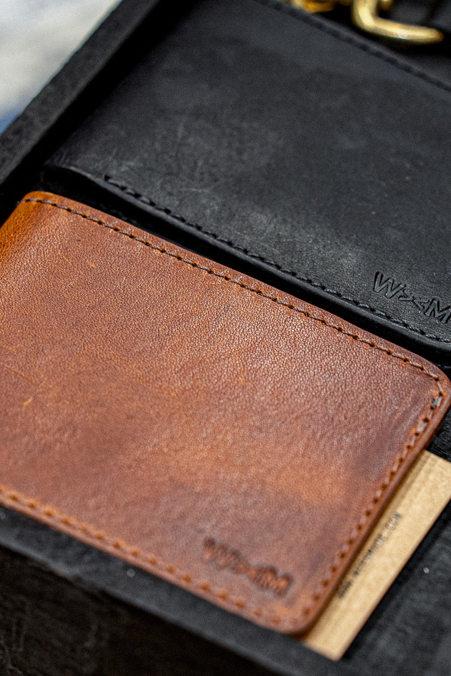 Close-up of tan Horween leather bi-fold wallet with card slot and embossed WiesMade logo.