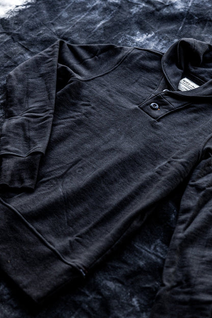 Shawl cardigan men's design in black, featuring a buttoned collar and laid flat for a detailed view.