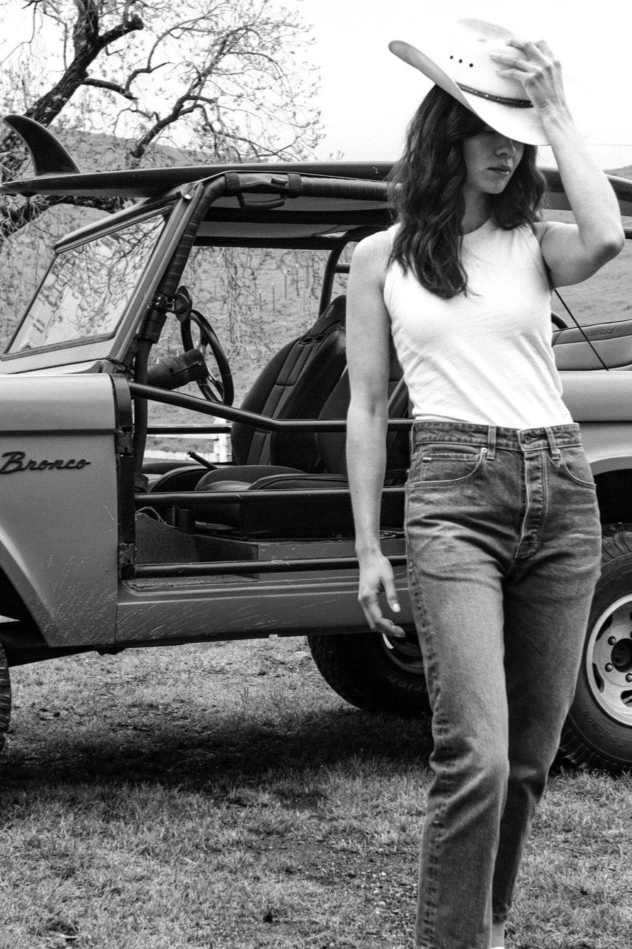 Women's Bolinas cotton tank in olive styled with jeans and a cowboy hat beside a vintage Bronco.