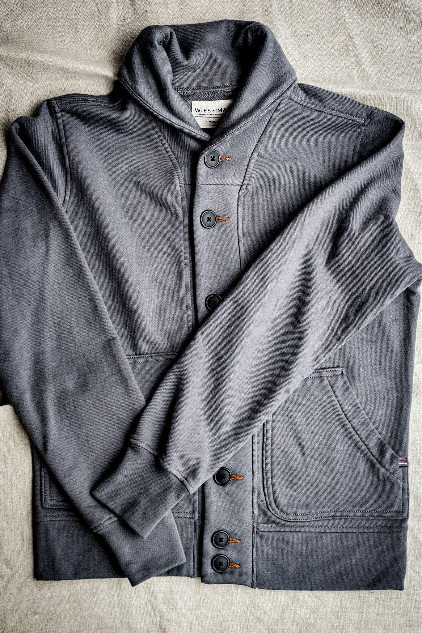 Pebble gray French terry shawl collar cardigan with contrast tobacco keyhole stitching and patch pockets.