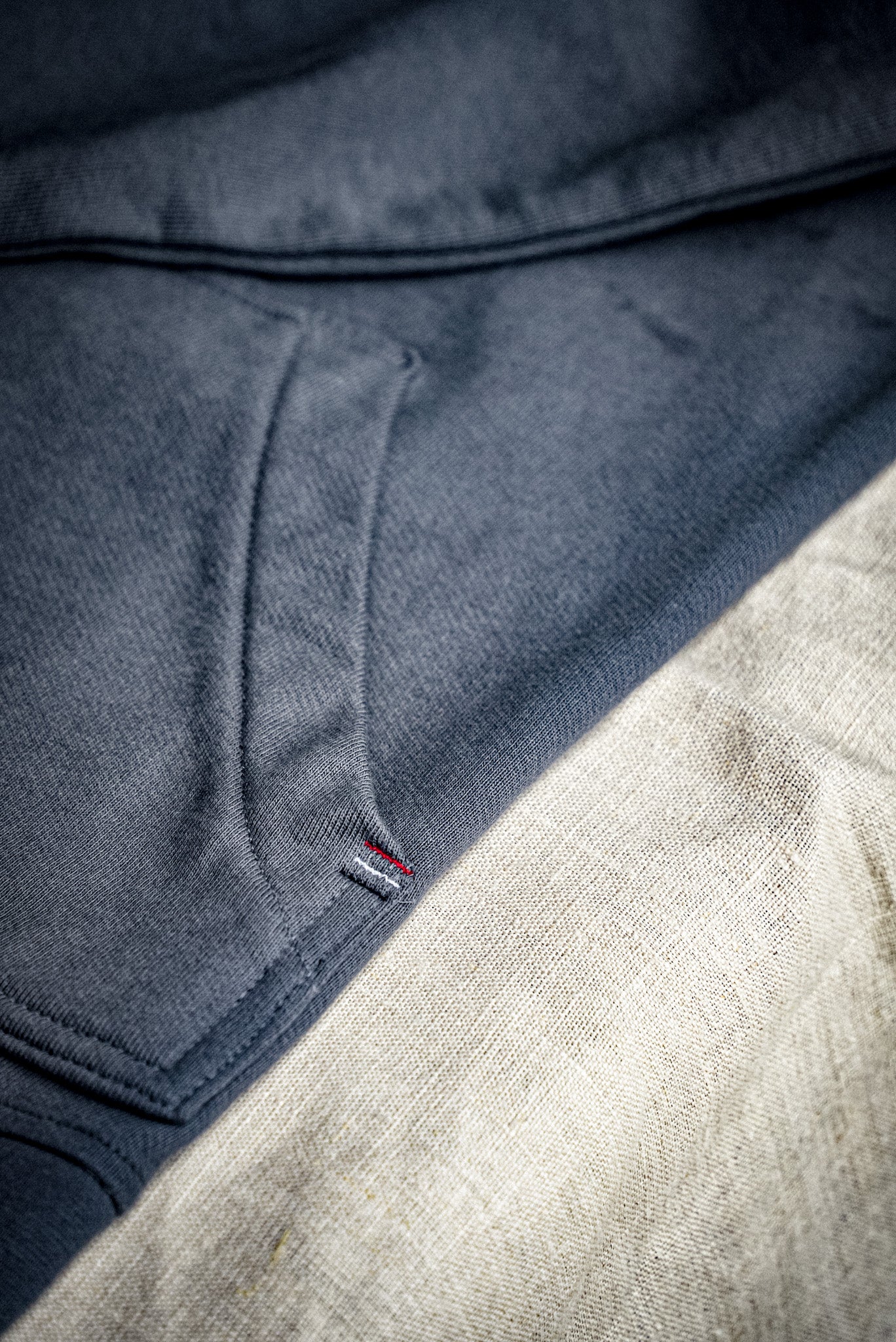 Close-up of the Bodega shawl cardigan's French terry knit and small woven flag label at the hem.