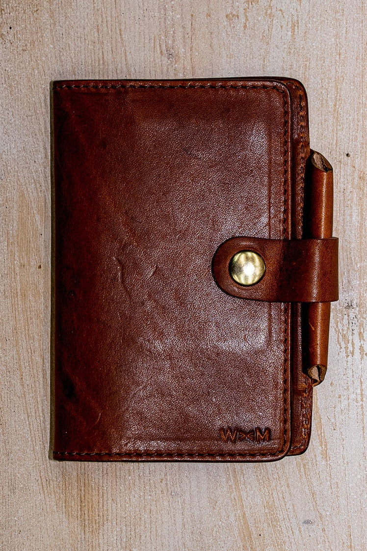 Tan Horween leather Field Notes cover with brass snap closure and leather pen loop.