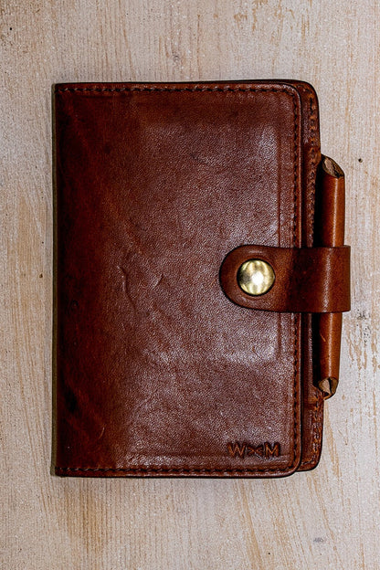 Tan Horween leather Field Notes cover with brass snap closure and leather pen loop.