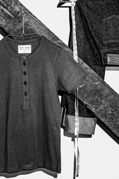 Reyes four-button Henley on a hanger beside folded selvedge denim jeans and a tape measure.