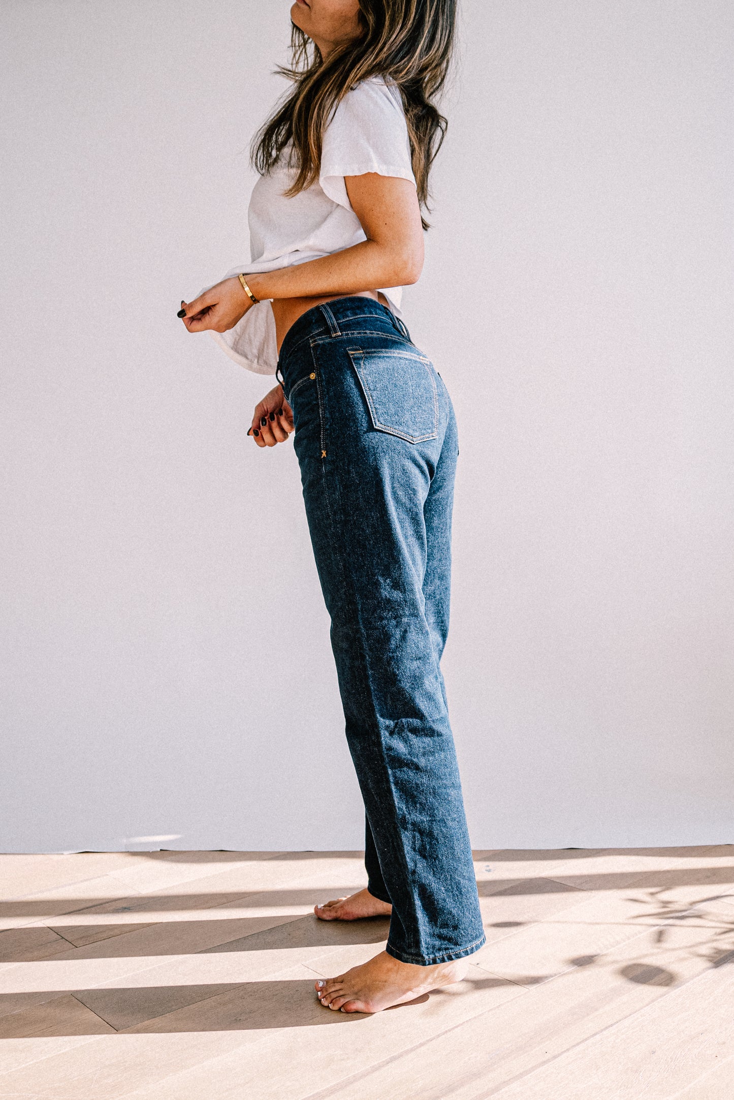 Side profile of Jackie ocean wash mid-rise wide-leg jeans on a barefoot model.