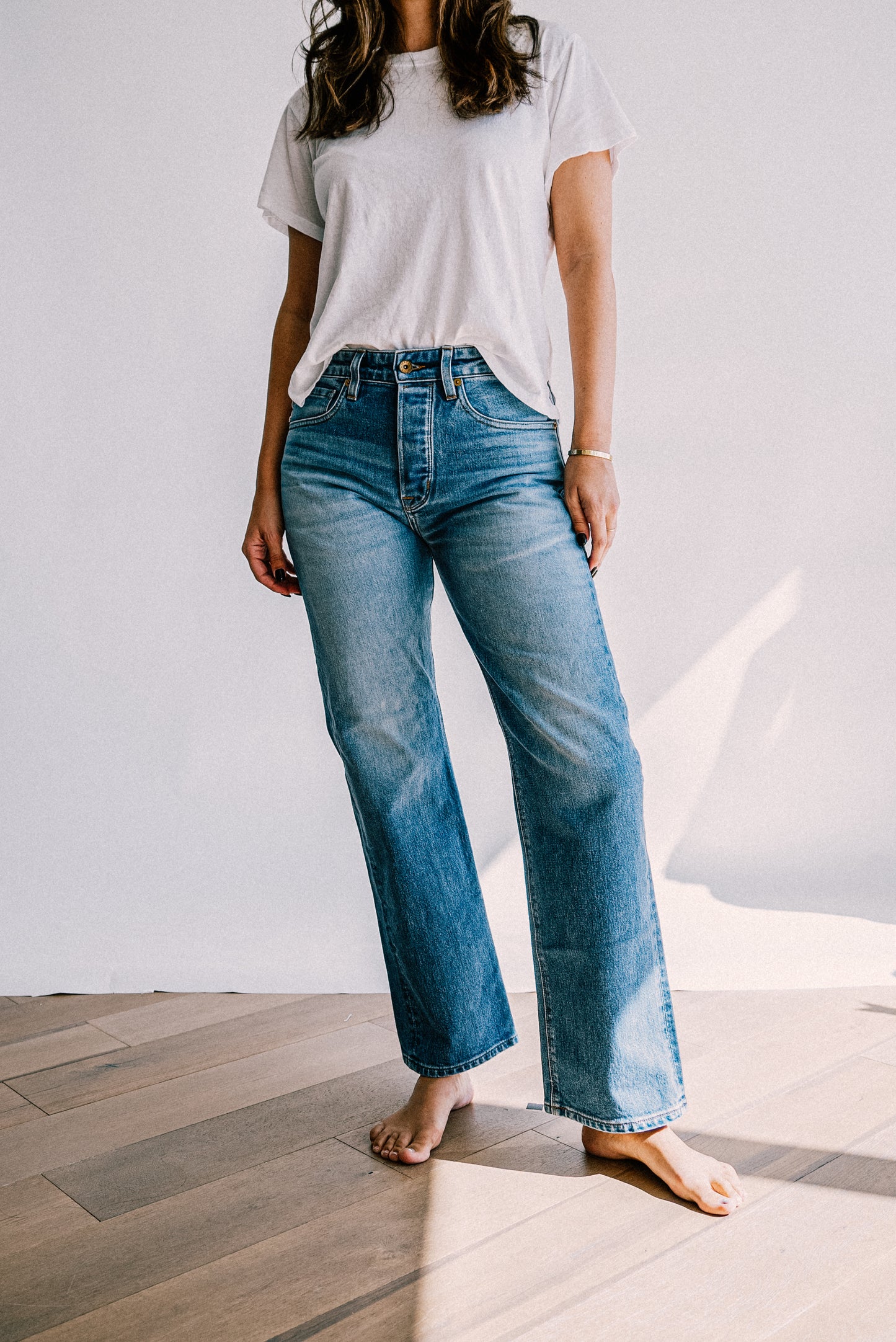 Premium denim jeans for women in a medium blue wash, designed with a high rise waist and straight leg silhouette for a flattering, relaxed style
