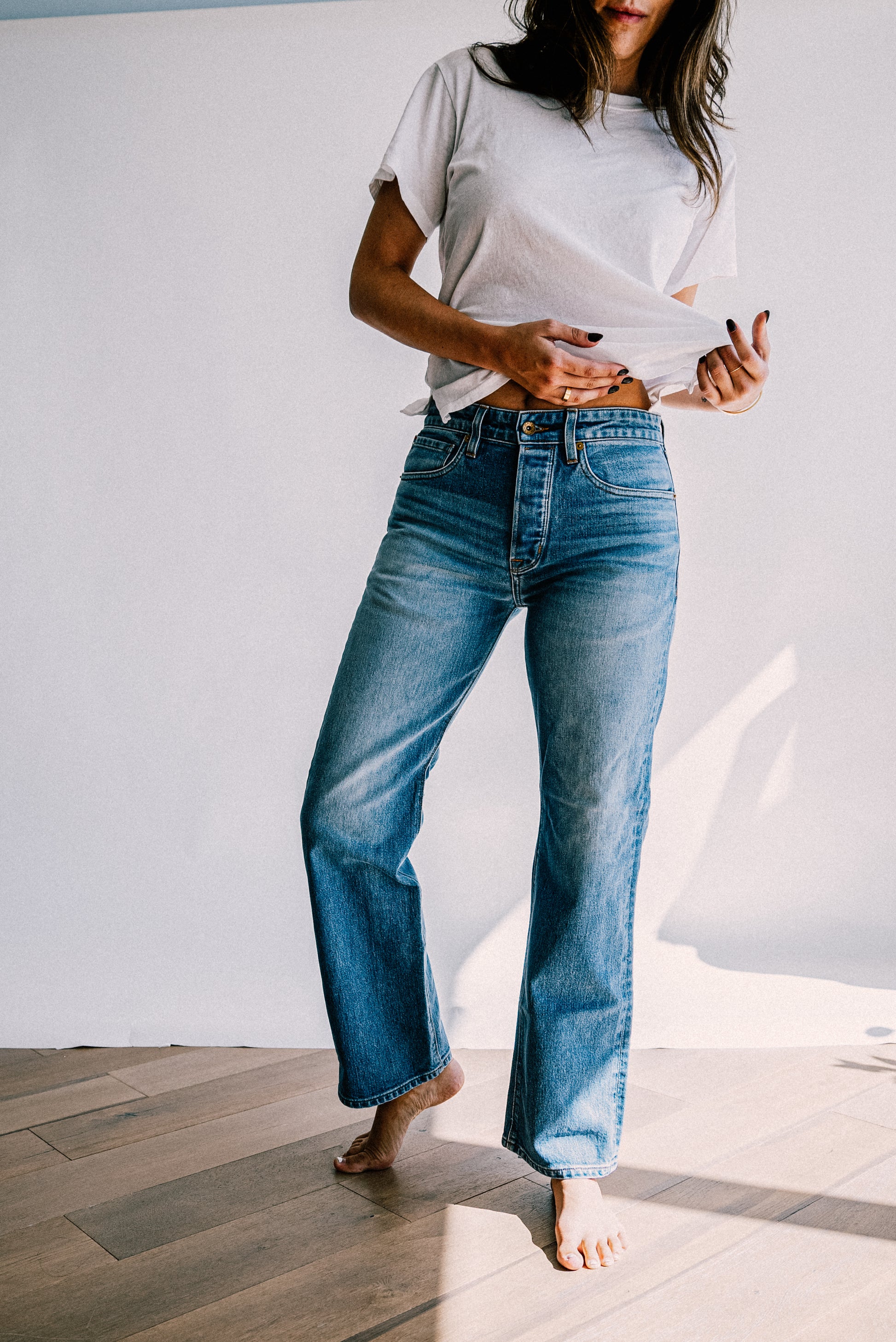 Women’s designer denim jeans crafted in a medium blue wash, featuring a high rise waist, straight leg fit, and subtle fading for a refined everyday style