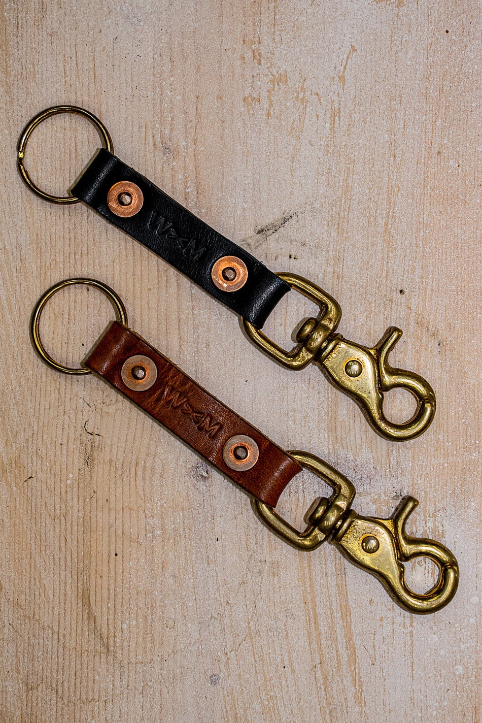 Black and brown Horween leather key clips with brass swivel snaps and copper rivets.