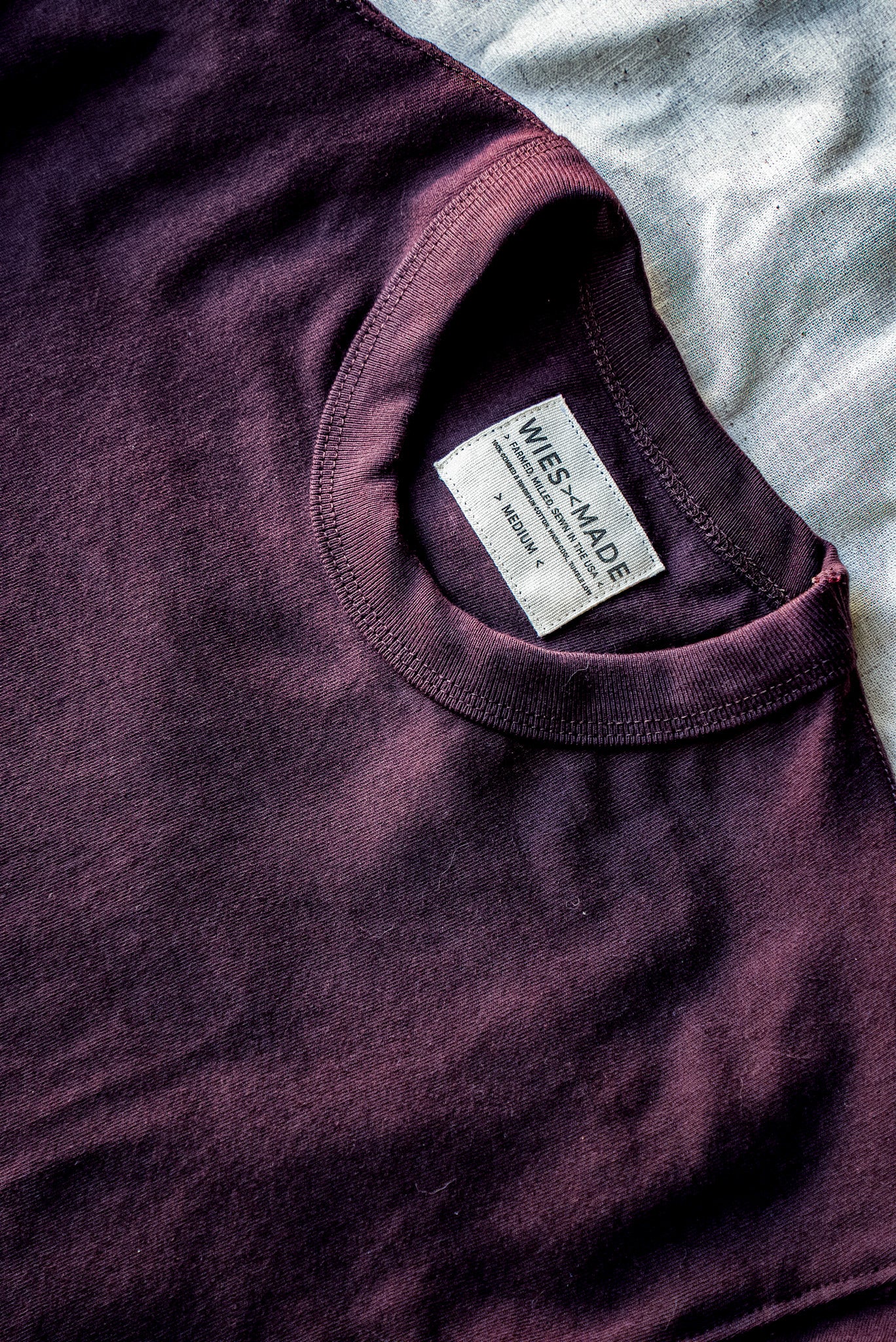 Close-up of oxblood heavyweight cotton tee collar with WiesMade neck label, size medium.