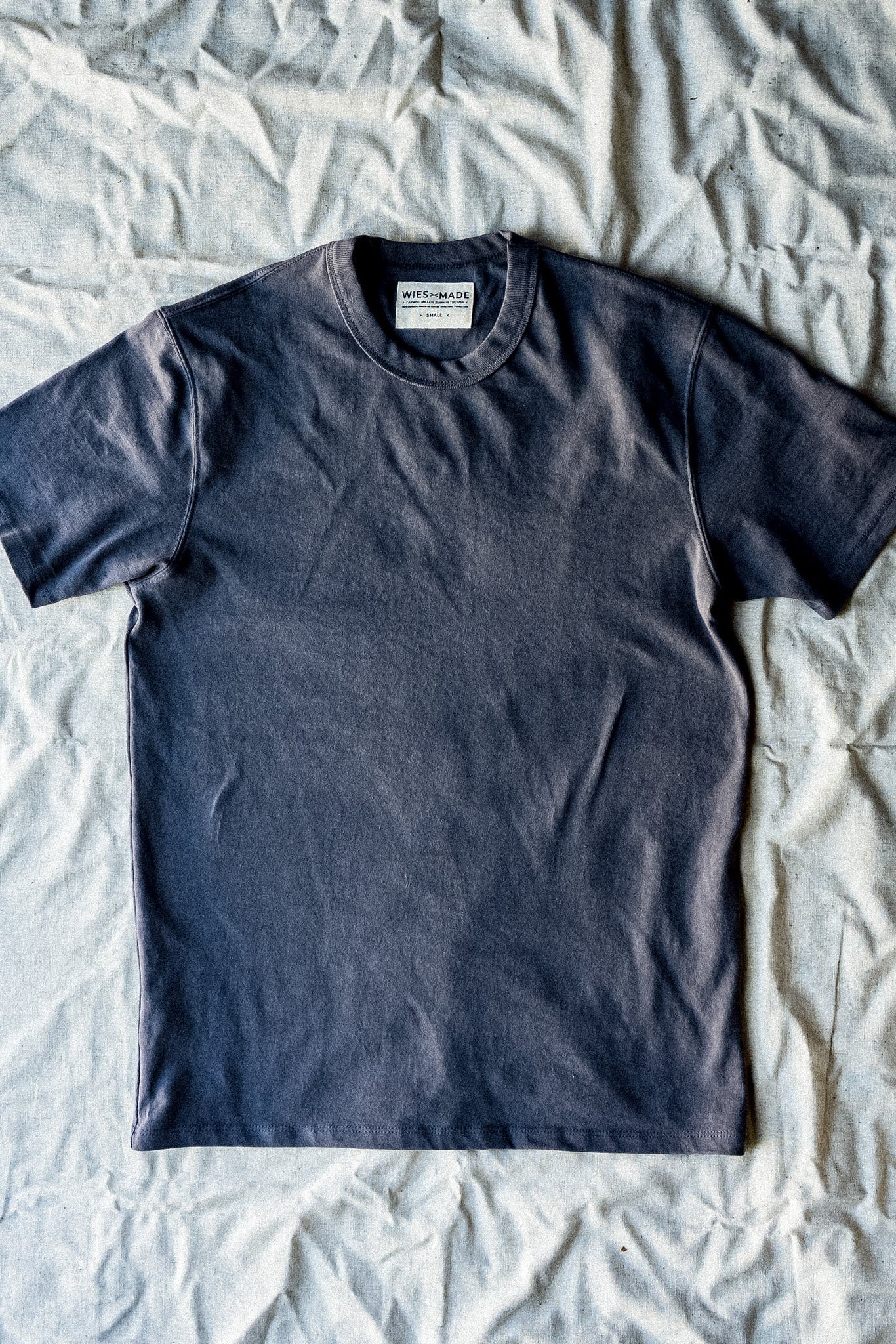 Men's pebble gray Bolinas t-shirt laid flat on textured surface