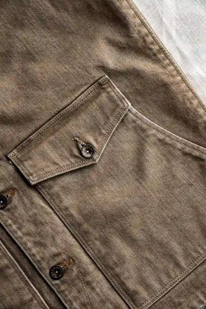 Close-up of a brown jacket with button details on a textured surface
