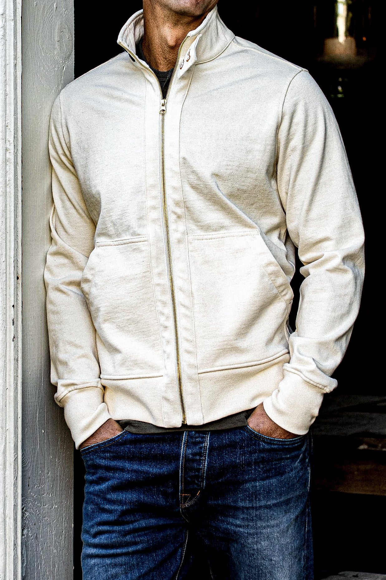 Man wearing the natural 12oz cotton Stinson moto zip jacket with brass zipper over jeans.
