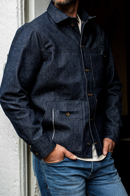 Front torso view of man wearing the WiesMade Nico indigo denim jacket open over a white tee and faded jeans.