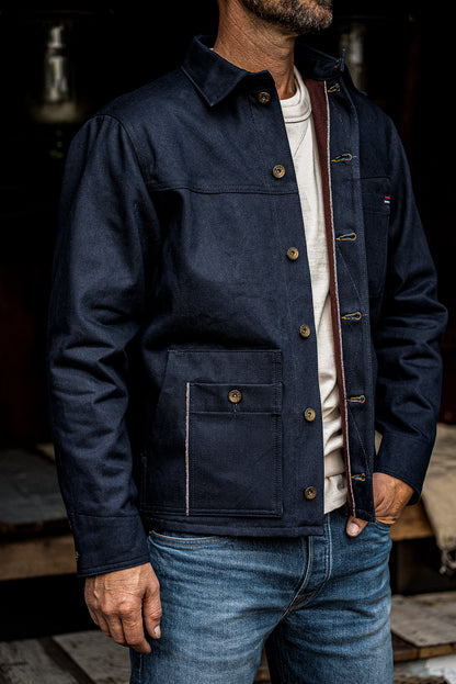 WiesMade Nico navy denim jacket open over a white tee, showing brown corduroy collar lining and brass buttons.