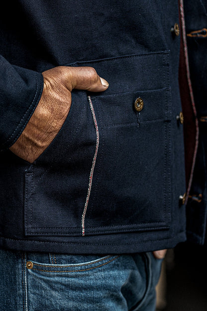 Close-up of WiesMade Nico navy jacket pocket detail with selvedge stitching and brass button.