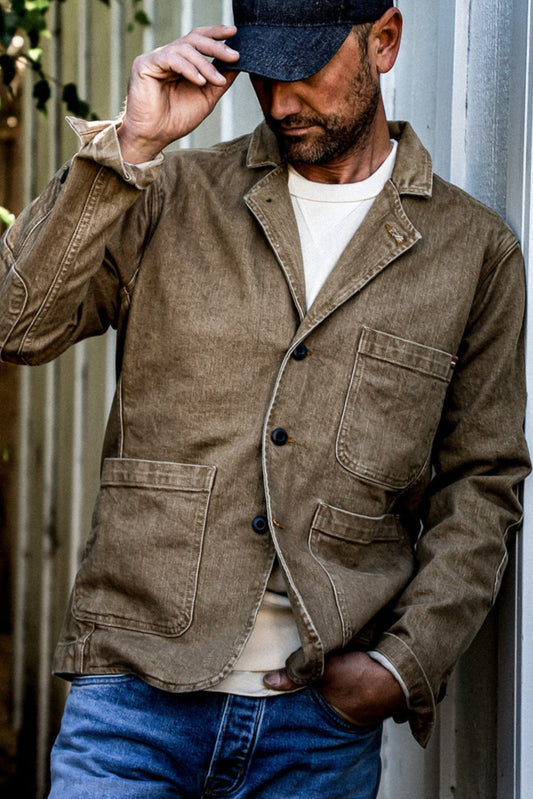 Wheat denim chore blazer worn open over a cream tee with blue jeans.