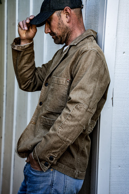 Wheat denim chore blazer shown side-on with patch pockets, elbow patch and buttoned cuffs.