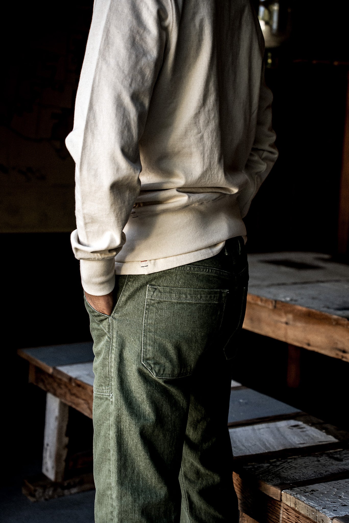 Rear view of olive Scout military denim jeans showing back pocket and topstitching.