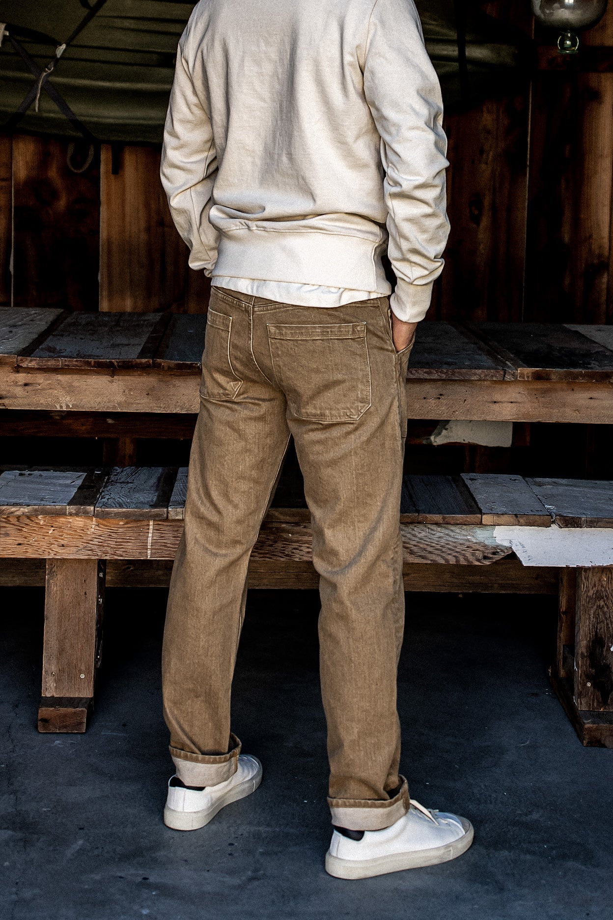 Back view of wheat Scout military denim jeans with patch pockets and cuffed hems.