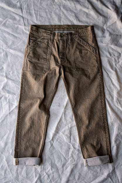 Wheat military-style Scout jeans laid flat with cuffed hems and patch pockets on linen.