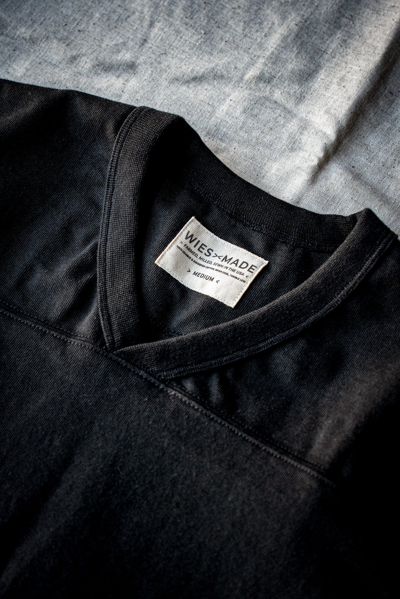 Close-up of Basalt 12oz cotton V-neck jersey collar with WiesMade made-in-USA label.