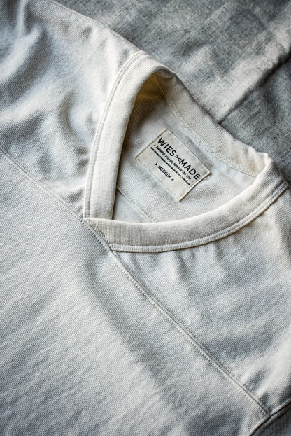 Close-up of natural cotton V-neck jersey collar with WiesMade label and yoke seam.