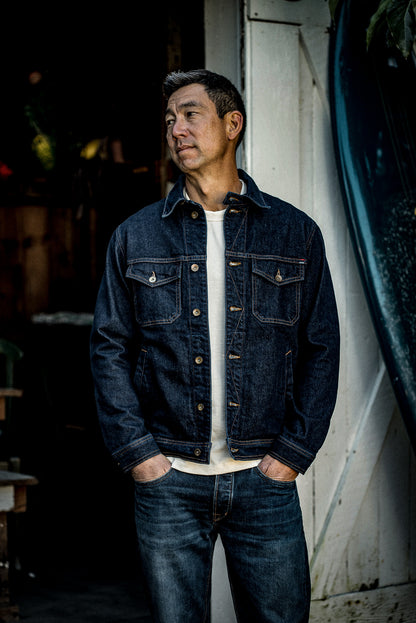 Man wearing the Artcher ocean broken twill denim jacket over a white tee, hands in pockets.