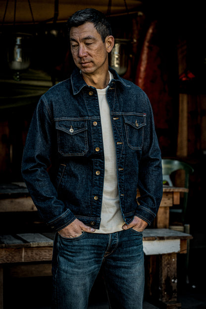 Man wearing the Artcher broken twill denim jacket in Ocean over a cream tee.