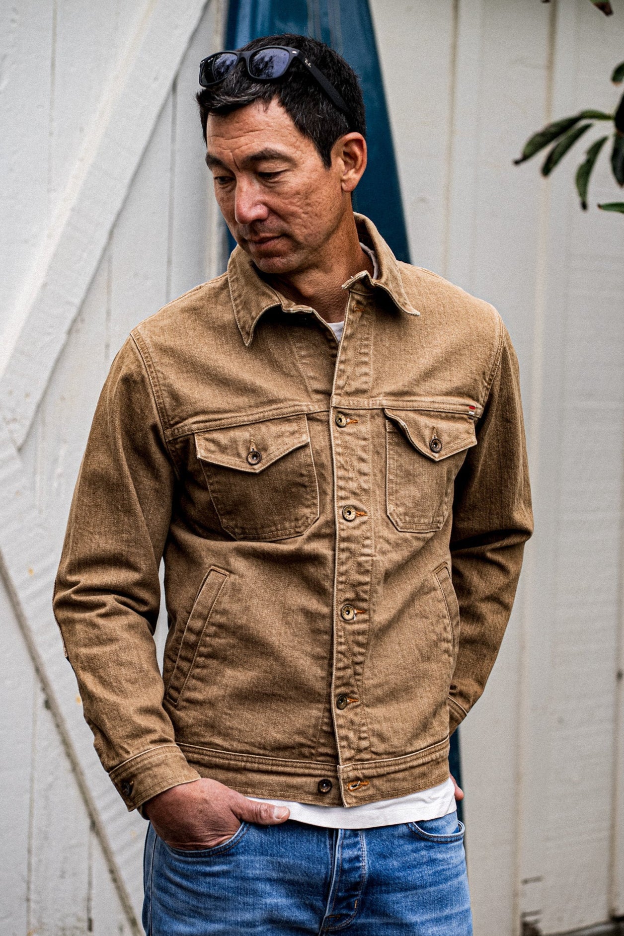 Man wearing wheat Artcher broken twill denim jacket with chest pockets over blue jeans.