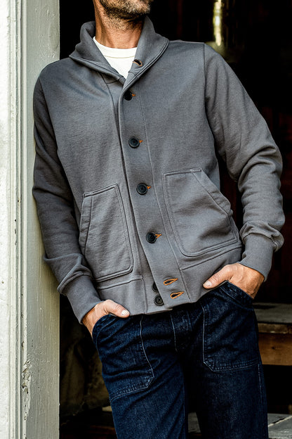 Man wearing the WiesMade Bodega grey pebble cardigan with shawl collar, button front, and patch pockets.