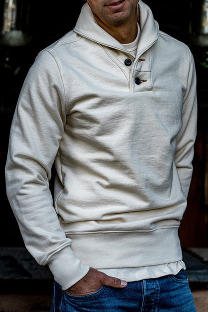 Natural cream shawl collar pullover in heavy French terry with two-button placket, worn with blue jeans.