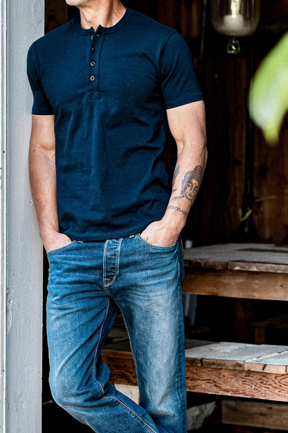 Man in a navy short-sleeve Bolinas Henley with four-button placket, paired with blue jeans.
