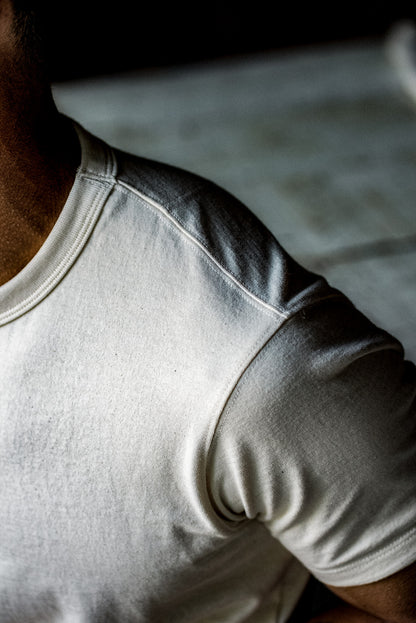 Close-up of the crew neck and shoulder seam on a natural cotton heavyweight tee.