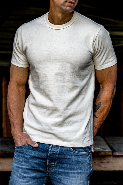 Man wearing a natural cotton heavyweight crewneck tee with blue jeans.