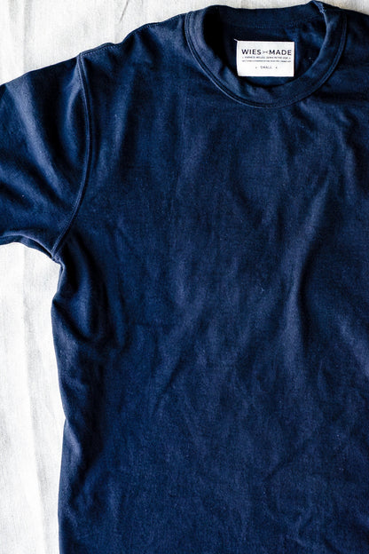 Navy heavyweight cotton tee laid flat on linen, showing crew neck and WiesMade size-small label.
