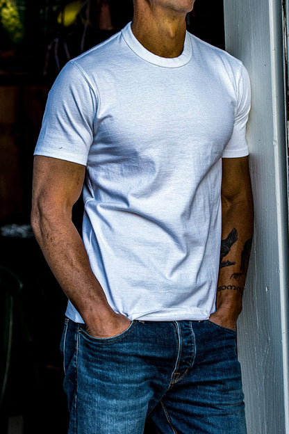On-model white heavyweight cotton tee worn tucked over blue jeans, hands in pockets.