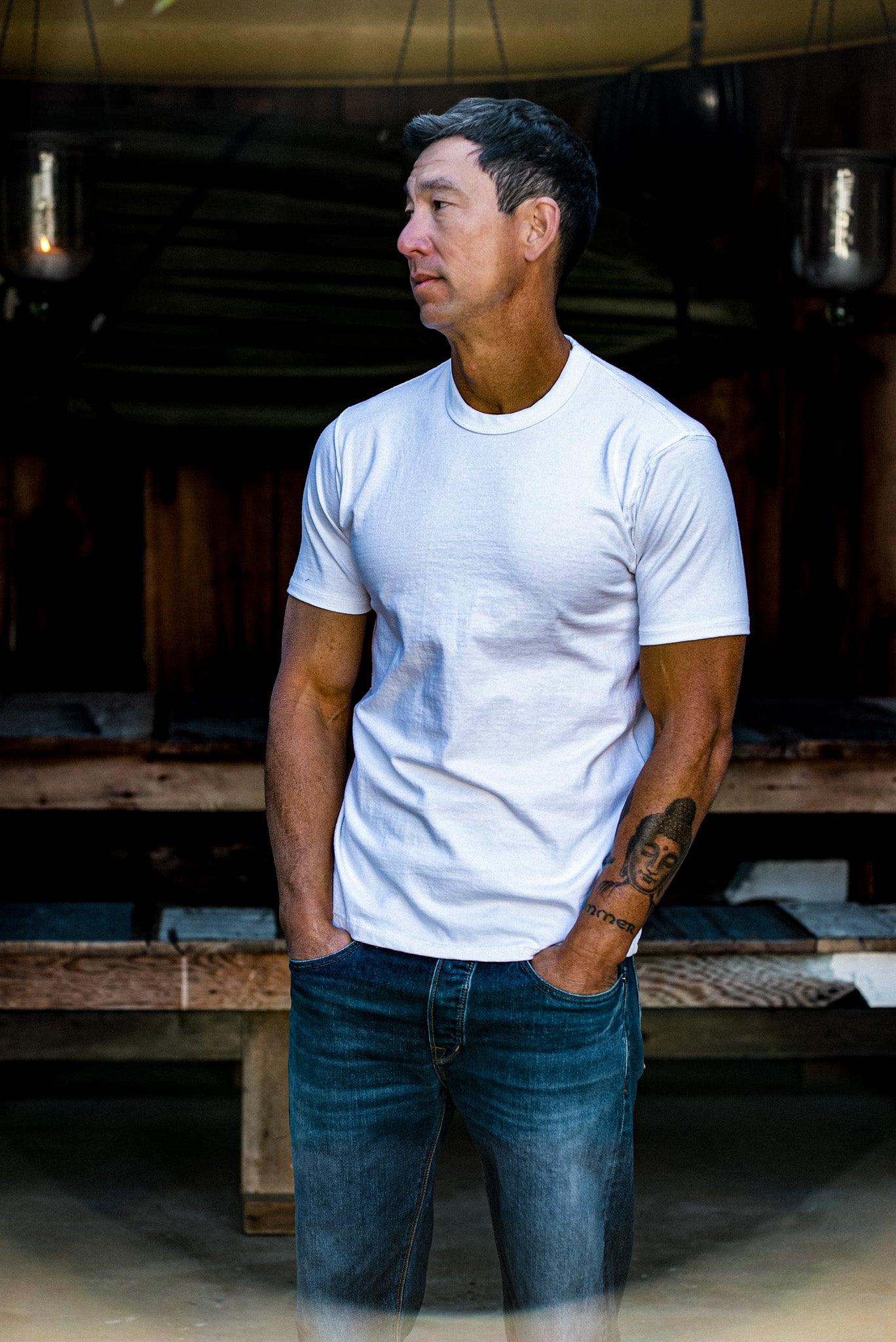 Model wears the white Bolinas heavyweight cotton tee with jeans in a rustic barn.