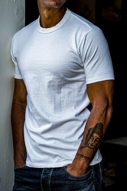 Person wearing white heavyweight cotton Bolinas tee with denim jeans, tailored fit on-model.