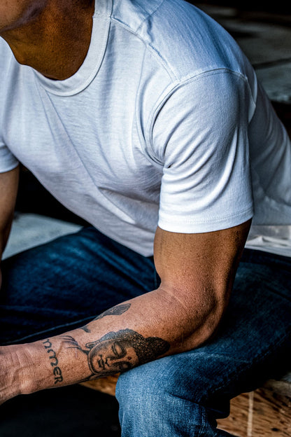 White heavyweight Bolinas tee worn on-model with denim jeans, showing tailored shoulder and drape.