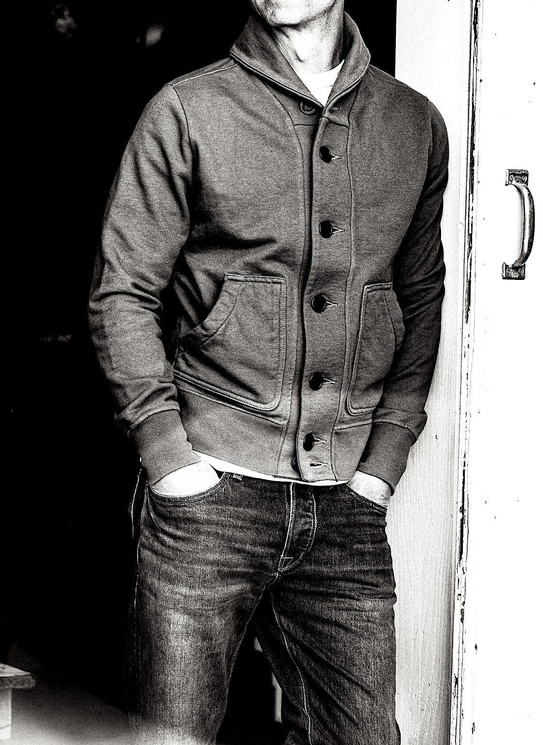 Man wearing buttoned shawl-collar French terry cardigan with patch pockets, paired with jeans.