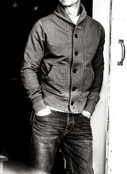 Man wearing buttoned shawl-collar French terry cardigan with patch pockets, paired with jeans.