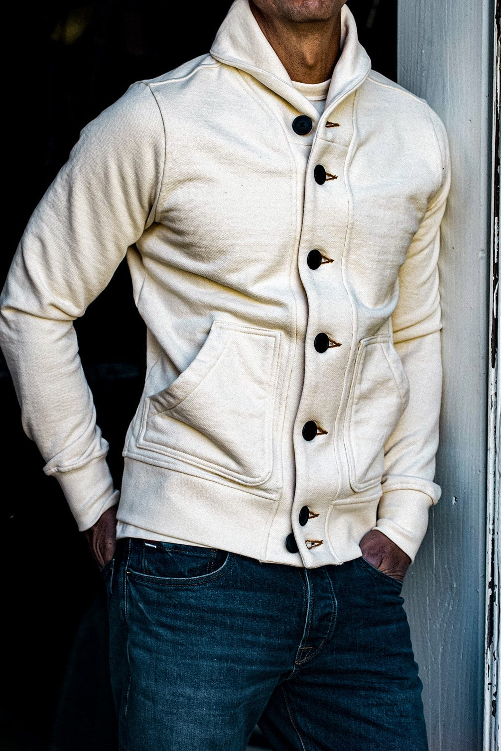 Natural cream shawl collar French terry cardigan worn with dark selvedge denim jeans.